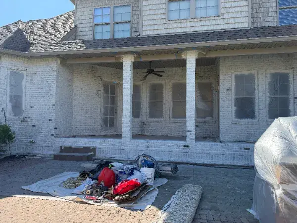 Covered porch with whitewashed brick columns and painting supplies laid out