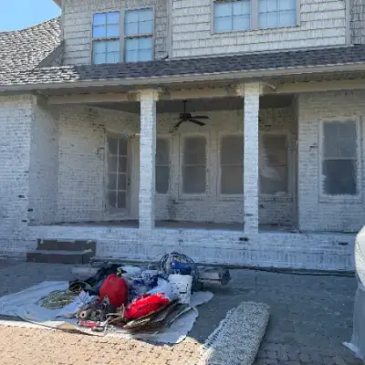 Covered porch with whitewashed brick columns and painting supplies laid out
