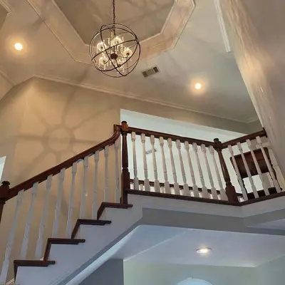 Foyer staircase with white balusters and a dark wood handrail
