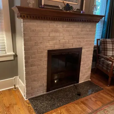 Living room with a white-painted brick fireplace and dark wood mantel