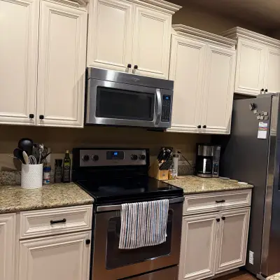 Kitchen with cream-painted cabinets, granite counters, and stainless steel appliances